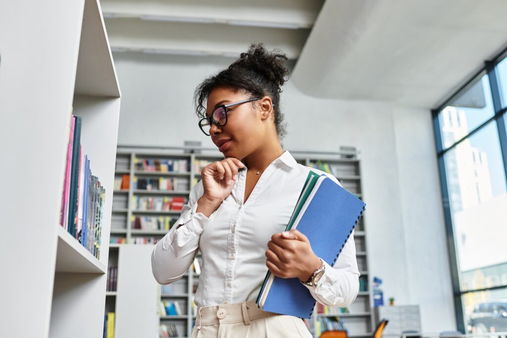 An inspiring African American teacher deep in thought while exploring educational resources
